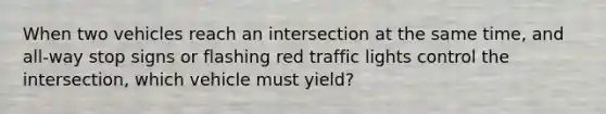 When two vehicles reach an intersection at the same time, and all-way stop signs or flashing red traffic lights control the intersection, which vehicle must yield?