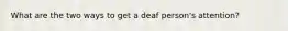 What are the two ways to get a deaf person's attention?