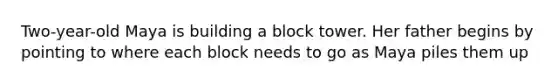 Two-year-old Maya is building a block tower. Her father begins by pointing to where each block needs to go as Maya piles them up