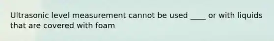 Ultrasonic level measurement cannot be used ____ or with liquids that are covered with foam