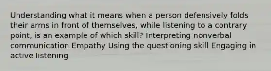 Understanding what it means when a person defensively folds their arms in front of themselves, while listening to a contrary point, is an example of which skill? Interpreting nonverbal communication Empathy Using the questioning skill Engaging in active listening