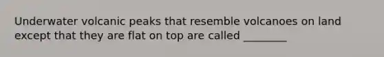 Underwater volcanic peaks that resemble volcanoes on land except that they are flat on top are called ________