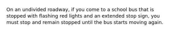 On an undivided roadway, if you come to a school bus that is stopped with flashing red lights and an extended stop sign, you must stop and remain stopped until the bus starts moving again.