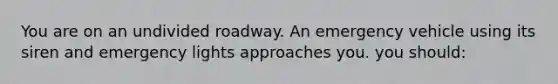 You are on an undivided roadway. An emergency vehicle using its siren and emergency lights approaches you. you should: