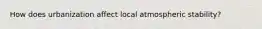 How does urbanization affect local atmospheric stability?