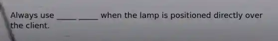 Always use _____ _____ when the lamp is positioned directly over the client.