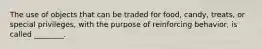 The use of objects that can be traded for food, candy, treats, or special privileges, with the purpose of reinforcing behavior, is called ________.