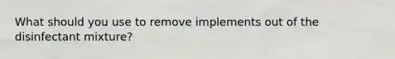 What should you use to remove implements out of the disinfectant mixture?