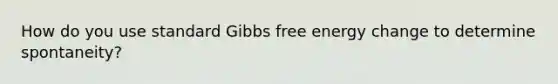 How do you use standard Gibbs free energy change to determine spontaneity?