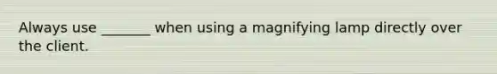 Always use _______ when using a magnifying lamp directly over the client.