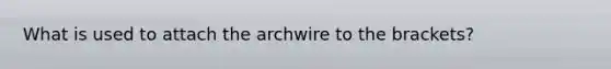 What is used to attach the archwire to the brackets?