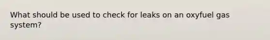 What should be used to check for leaks on an oxyfuel gas system?