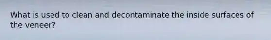 What is used to clean and decontaminate the inside surfaces of the veneer?