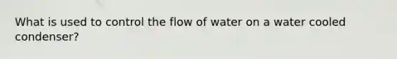 What is used to control the flow of water on a water cooled condenser?