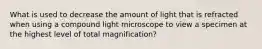 What is used to decrease the amount of light that is refracted when using a compound light microscope to view a specimen at the highest level of total magnification?