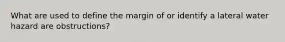 What are used to define the margin of or identify a lateral water hazard are obstructions?