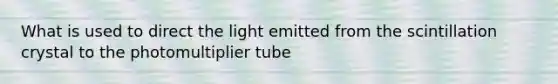 What is used to direct the light emitted from the scintillation crystal to the photomultiplier tube