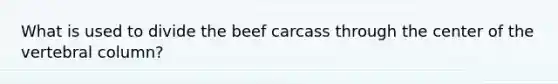 What is used to divide the beef carcass through the center of the vertebral column?