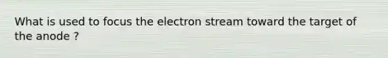 What is used to focus the electron stream toward the target of the anode ?