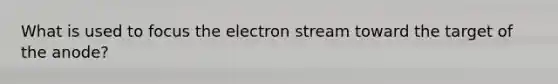 What is used to focus the electron stream toward the target of the anode?