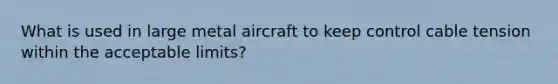 What is used in large metal aircraft to keep control cable tension within the acceptable limits?