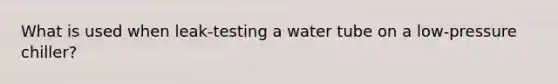 What is used when leak-testing a water tube on a low-pressure chiller?