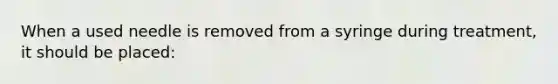 When a used needle is removed from a syringe during treatment, it should be placed: