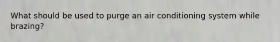 What should be used to purge an air conditioning system while brazing?