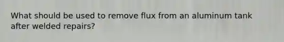 What should be used to remove flux from an aluminum tank after welded repairs?