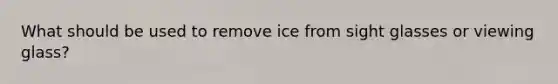 What should be used to remove ice from sight glasses or viewing glass?
