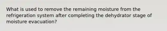What is used to remove the remaining moisture from the refrigeration system after completing the dehydrator stage of moisture evacuation?