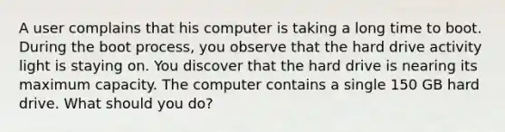 A user complains that his computer is taking a long time to boot. During the boot process, you observe that the hard drive activity light is staying on. You discover that the hard drive is nearing its maximum capacity. The computer contains a single 150 GB hard drive. What should you do?