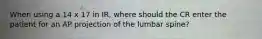 When using a 14 x 17 in IR, where should the CR enter the patient for an AP projection of the lumbar spine?