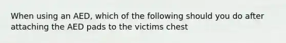 When using an AED, which of the following should you do after attaching the AED pads to the victims chest