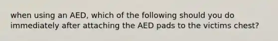 when using an AED, which of the following should you do immediately after attaching the AED pads to the victims chest?