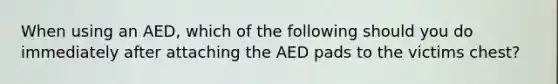 When using an AED, which of the following should you do immediately after attaching the AED pads to the victims chest?