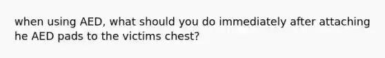 when using AED, what should you do immediately after attaching he AED pads to the victims chest?