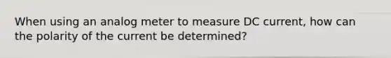 When using an analog meter to measure DC current, how can the polarity of the current be determined?