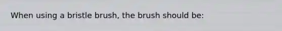 When using a bristle brush, the brush should be: