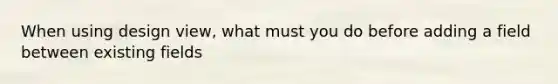 When using design view, what must you do before adding a field between existing fields