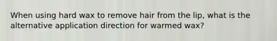 When using hard wax to remove hair from the lip, what is the alternative application direction for warmed wax?