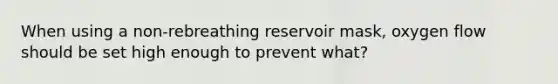 When using a non-rebreathing reservoir mask, oxygen flow should be set high enough to prevent what?