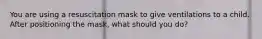 You are using a resuscitation mask to give ventilations to a child. After positioning the mask, what should you do?