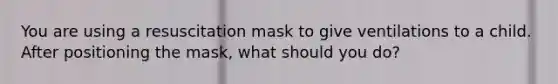 You are using a resuscitation mask to give ventilations to a child. After positioning the mask, what should you do?