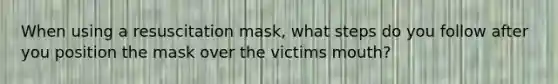 When using a resuscitation mask, what steps do you follow after you position the mask over the victims mouth?