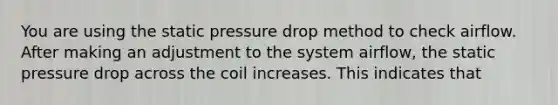 You are using the static pressure drop method to check airflow. After making an adjustment to the system airflow, the static pressure drop across the coil increases. This indicates that