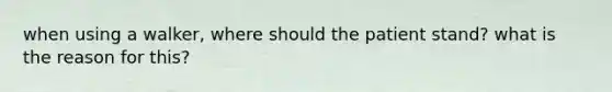 when using a walker, where should the patient stand? what is the reason for this?