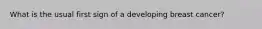 What is the usual first sign of a developing breast cancer?