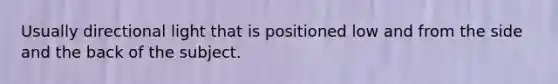 Usually directional light that is positioned low and from the side and the back of the subject.
