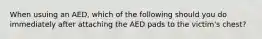 When usuing an AED, which of the following should you do immediately after attaching the AED pads to the victim's chest?